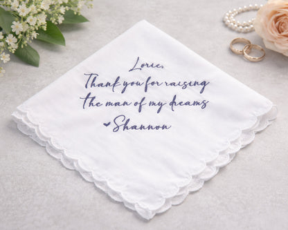 White handkerchief with purple text on a light gray background with flowers and rings.