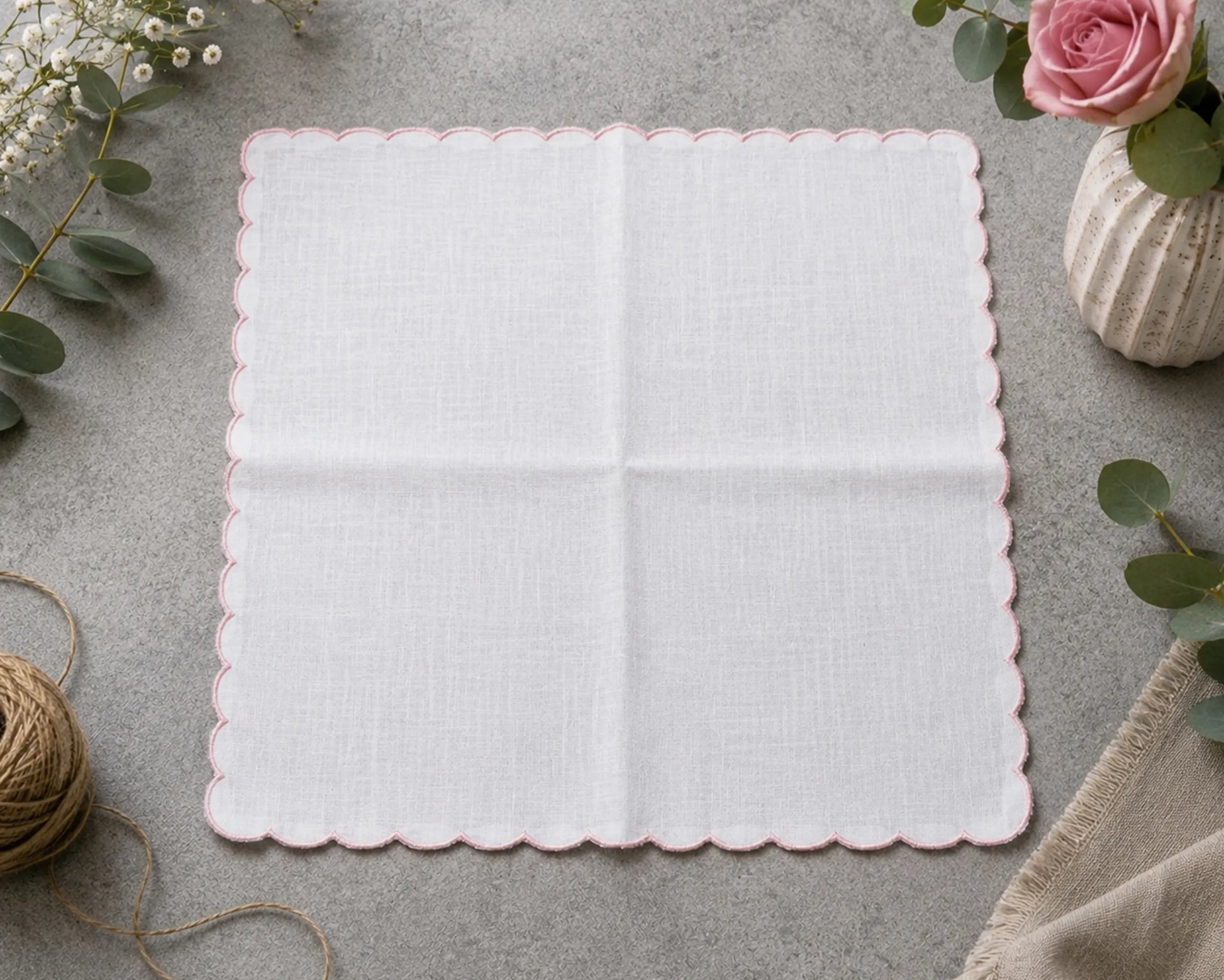 White doily with scalloped edge on a gray surface with decorative elements.