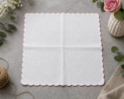 White doily with scalloped edge on a gray surface with decorative elements.