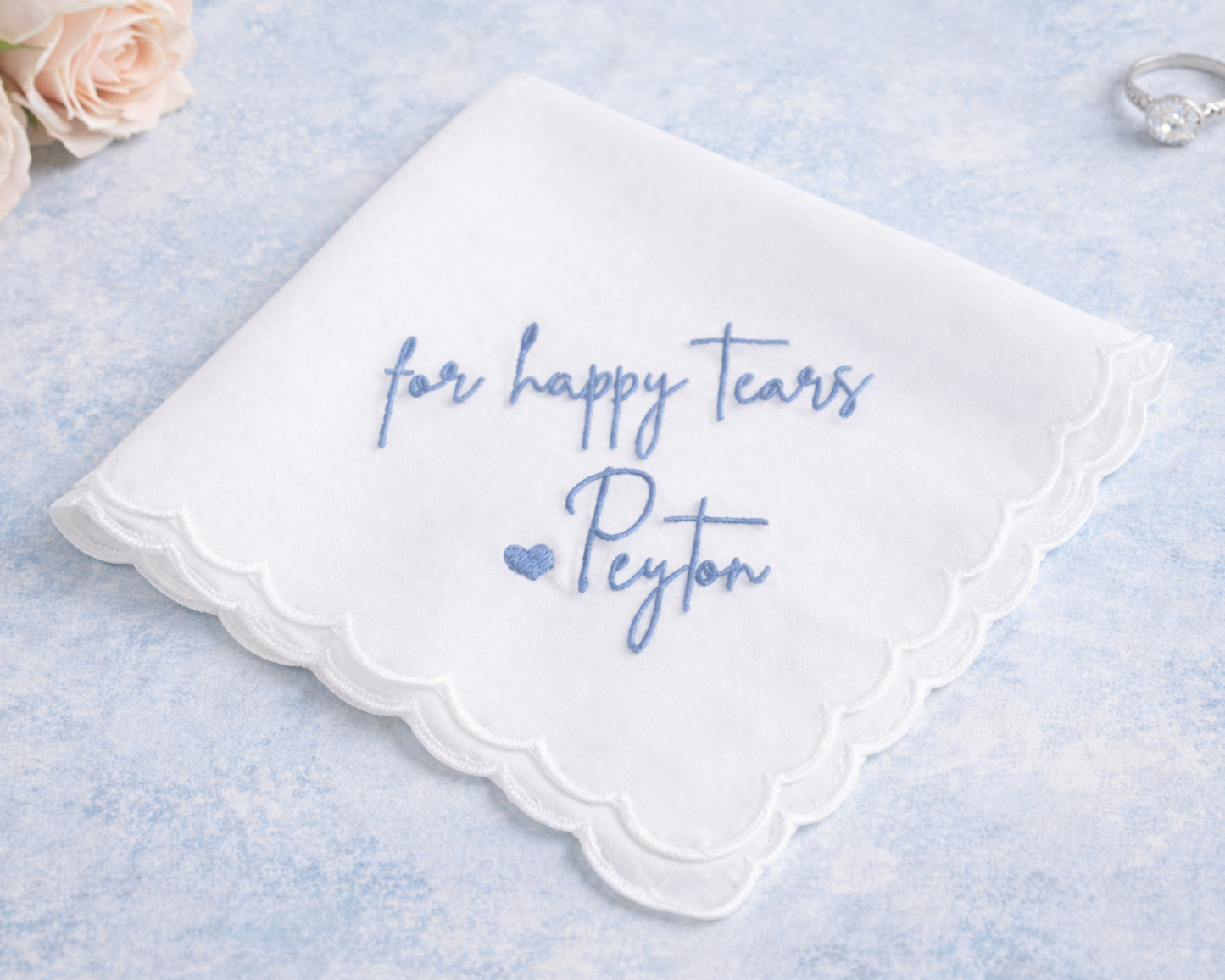 White handkerchief with blue text 'for happy tears Peyton' on a light blue background