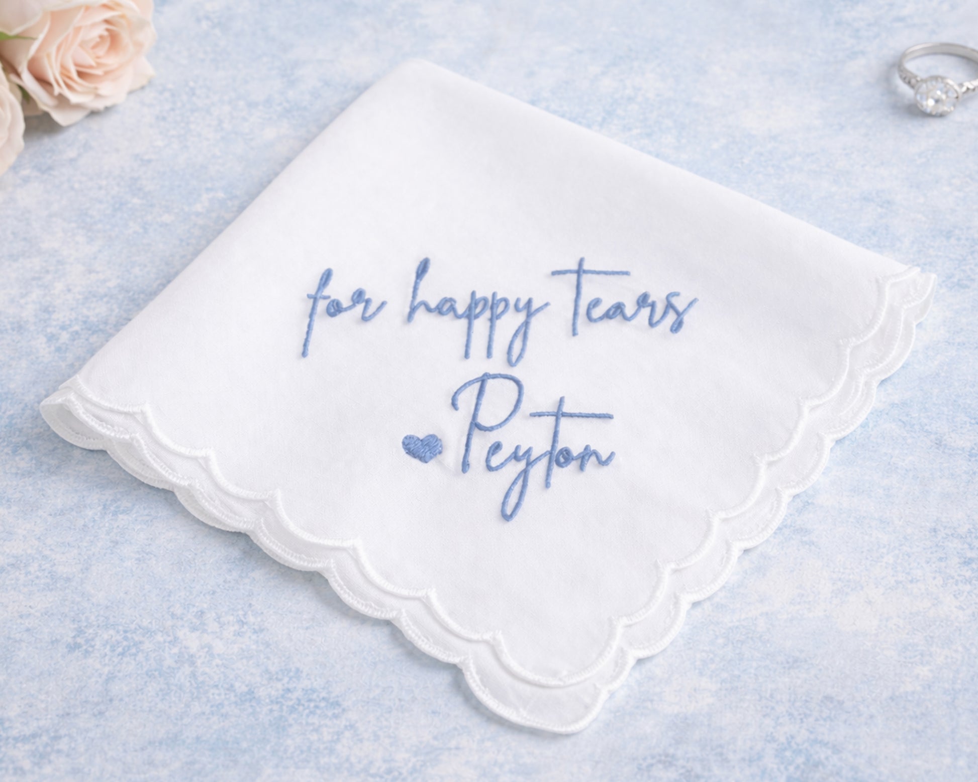 White handkerchief with blue text 'for happy tears Peyton' on a light blue background