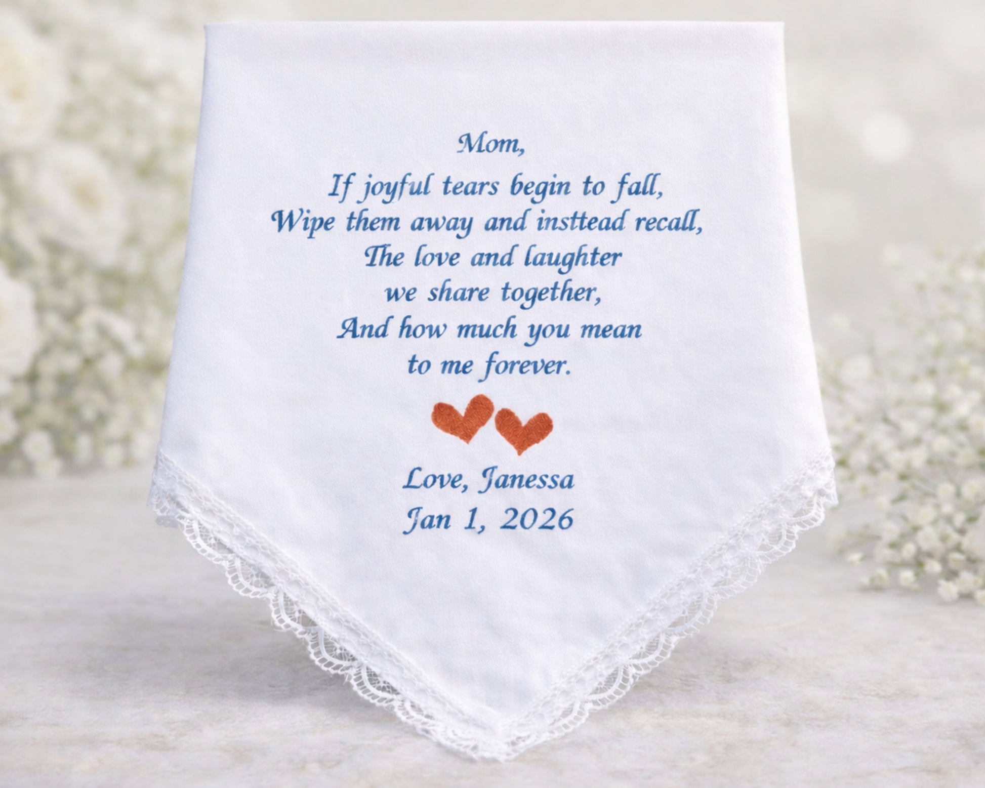 White handkerchief with embroidered text and hearts on a light background