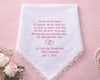 White handkerchief with pink text on a pink background with flowers and jewelry.