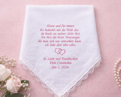 White handkerchief with pink text on a pink background with flowers and jewelry.