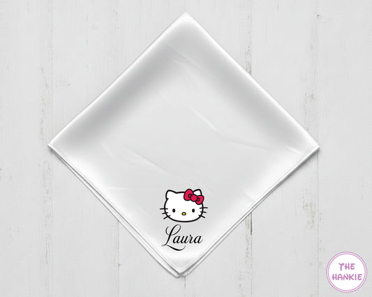 White napkin with Hello Kitty logo and 'Laura' text on a light wooden surface, branded 'The Hankie'.
