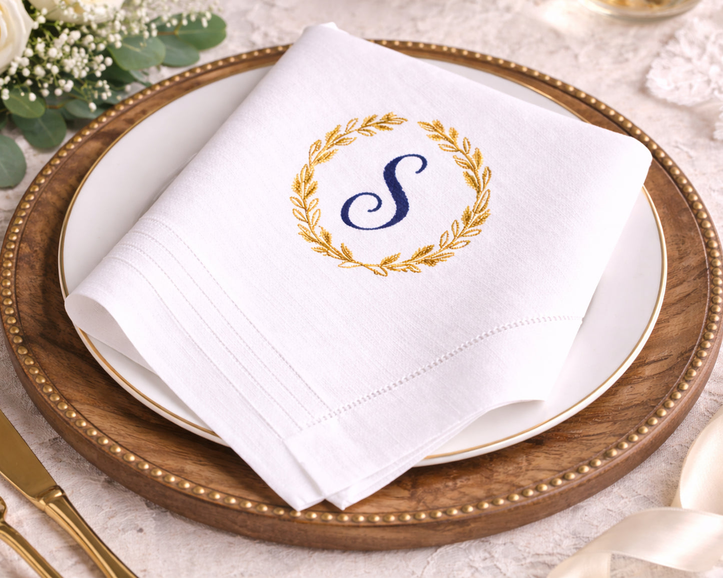 White napkin with a monogram 'S' on a wooden charger plate