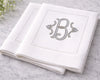 White napkin with silver monogram 'B' on a marble surface