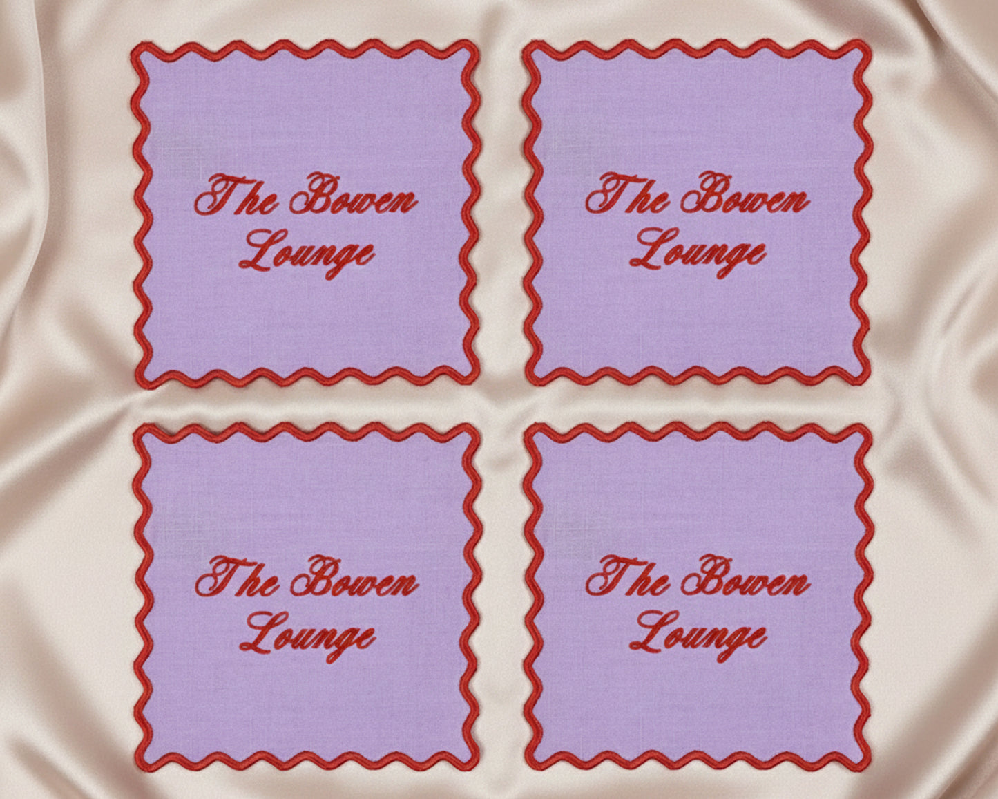 Ruby red linen napkins with white wave edges featuring "a 'tini bit merry" in white vinyl script for holiday hosting.