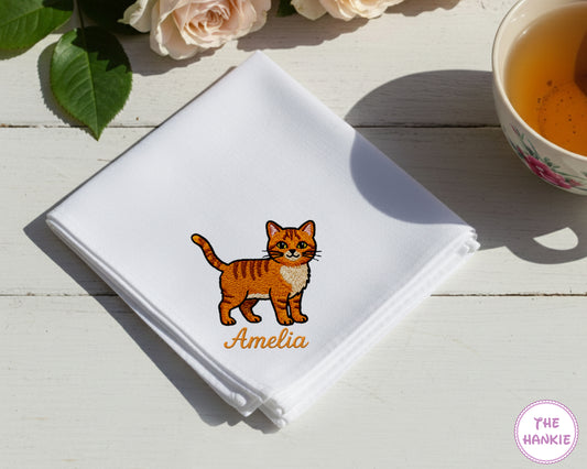 A soft sky blue cotton handkerchief personalized with the name "amelia" and an embroidered cat character.