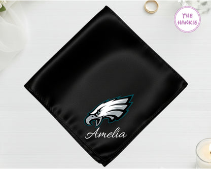 A midnight onyx black luxury satin pocket square customized with the name "Amelia" below a high-definition vinyl Philadelphia Eagles team icon.