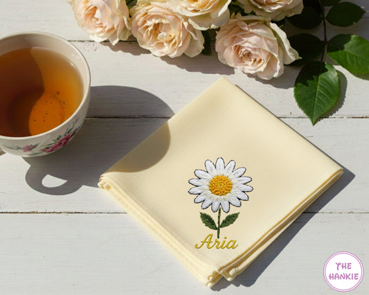 A yellow  premium cotton handkerchief customized with the name "aria" and a detailed white flower embroidery.