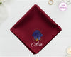 A midnight burgundy cotton handkerchief customized with the name "Ava" below a mystical indigo and gold Virgo goddess design.