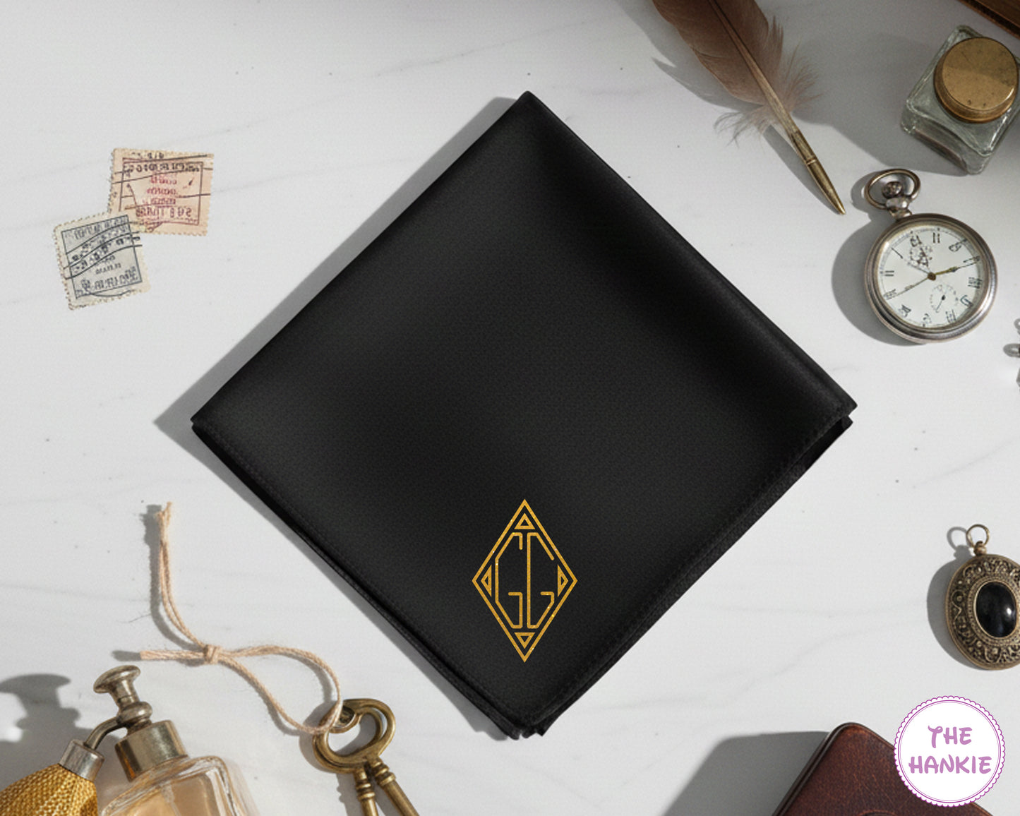 A sleek black cotton handkerchief with a bespoke gold vinyl "GG" monogram featuring a sharp, modern geometric diamond design.