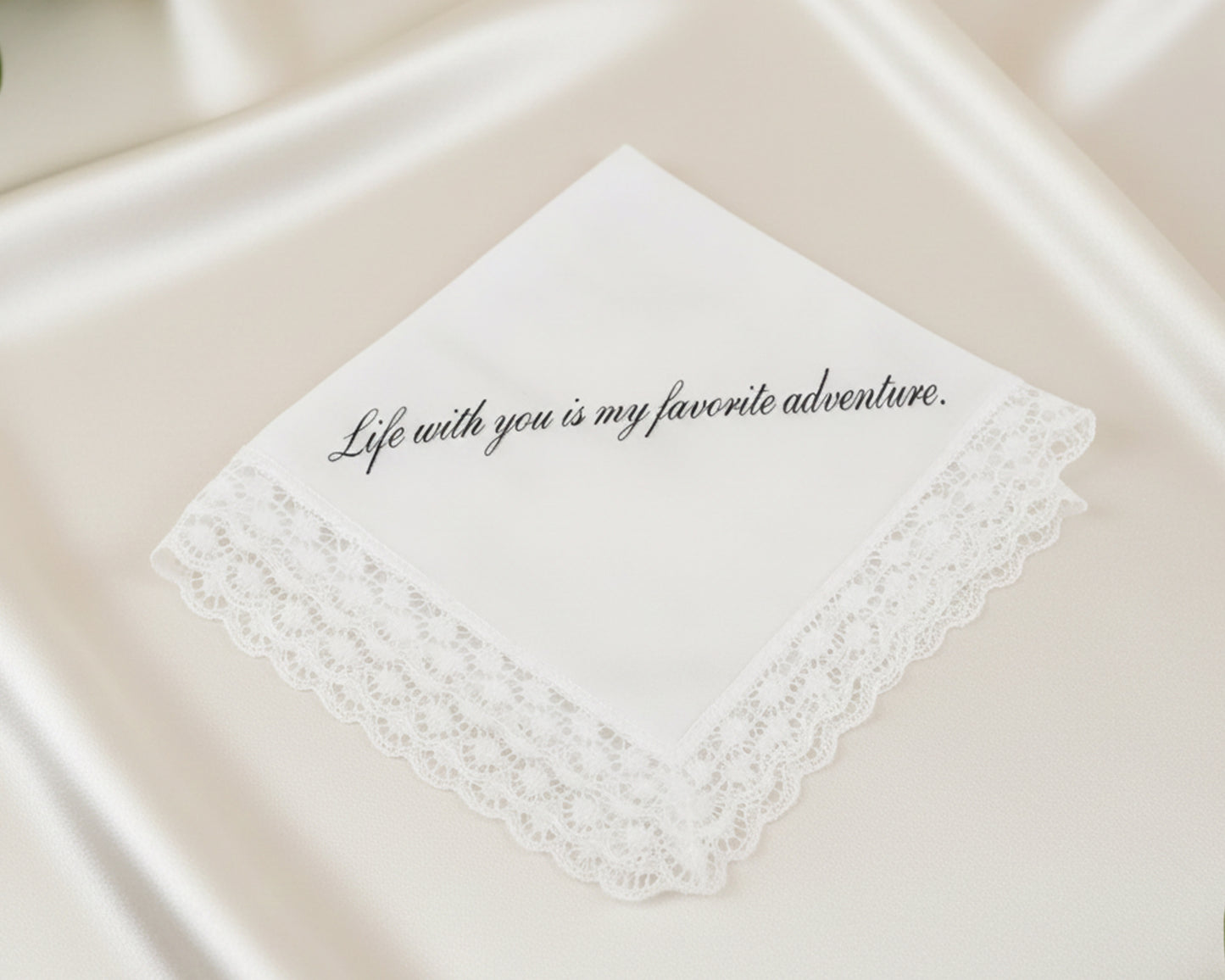 White dinner napkin with a soft blue embroidered ribbon bow and personalized letter B monogram