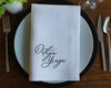 Premium linen napkin featuring a forest green laurel wreath framing a personalized serif initial