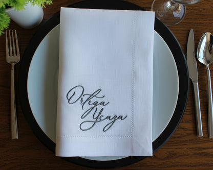 Premium linen napkin featuring a forest green laurel wreath framing a personalized serif initial