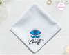 A crisp white cotton handkerchief personalized with "Charlotte" below an intricate blue and black bohemian-style evil eye with detailed eyelashes.