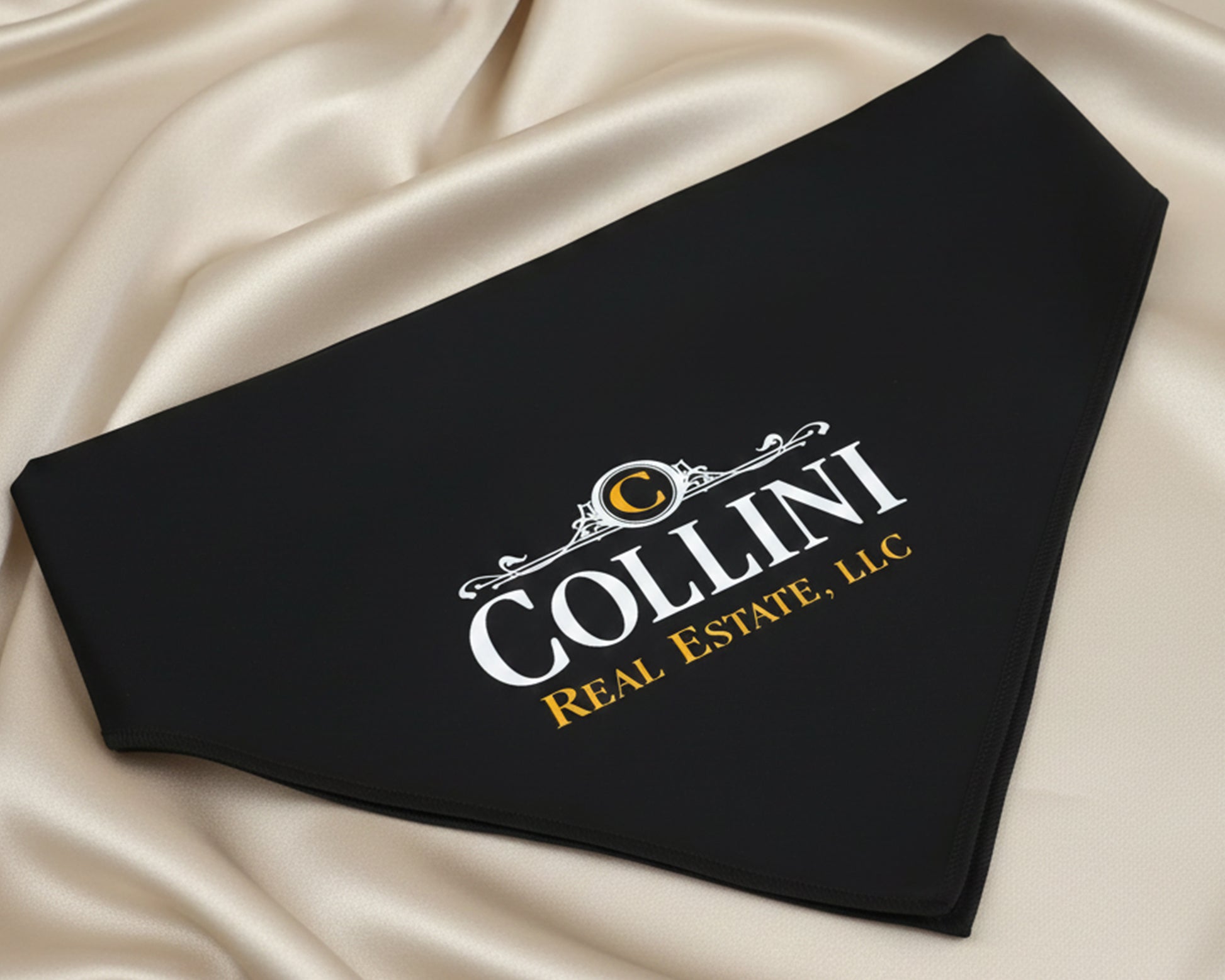 An obsidian black pet bandana displaying a white and yellow vinyl corporate logo for "Collini Real Estate, LLC".