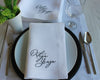 Custom name embroidery with a soft blue ribbon bow motif on a white hemstitched cotton cloth