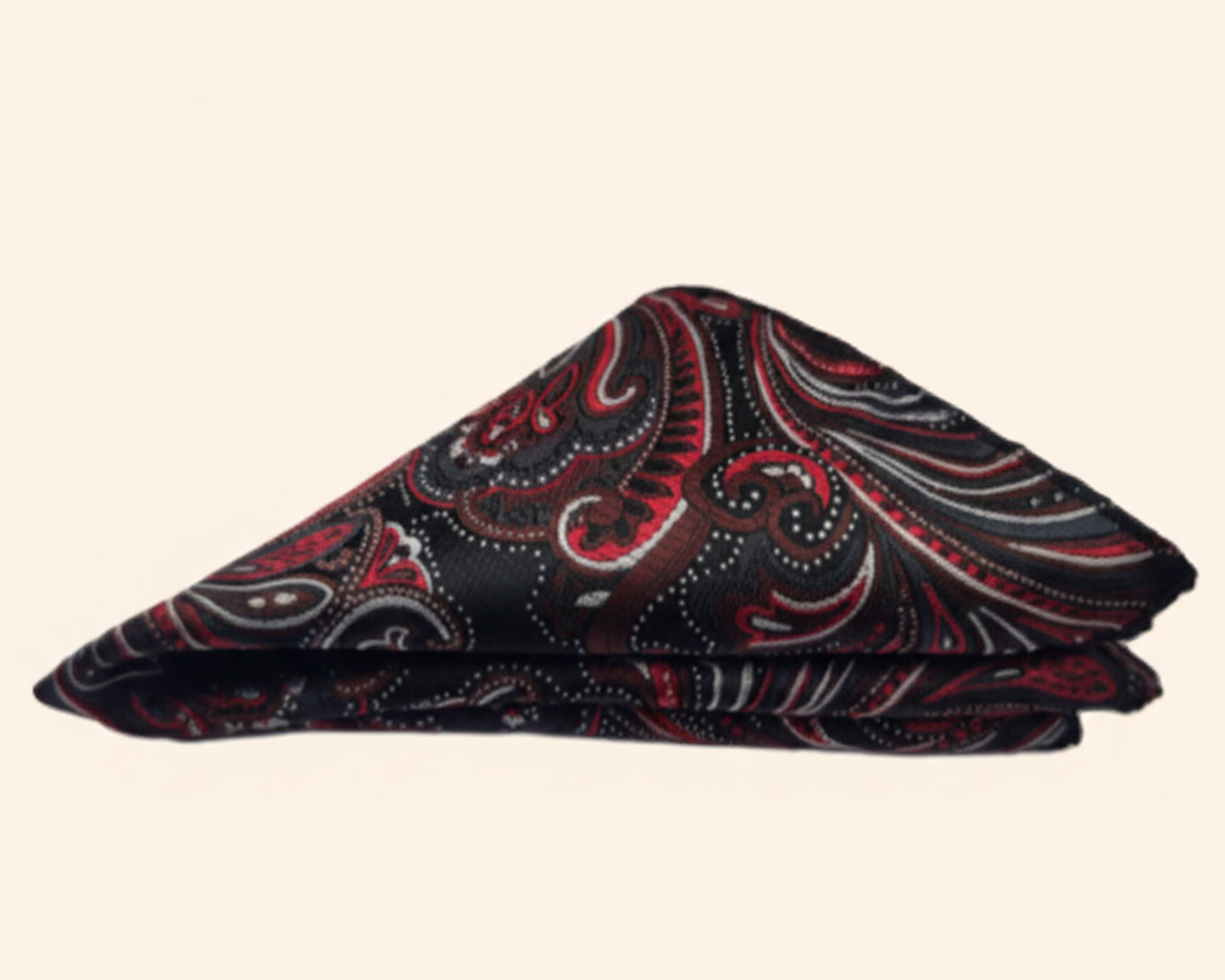 Close up of a crimson paisley silk pocket square styled in a classic puff fold showing the intricate silk texture.
