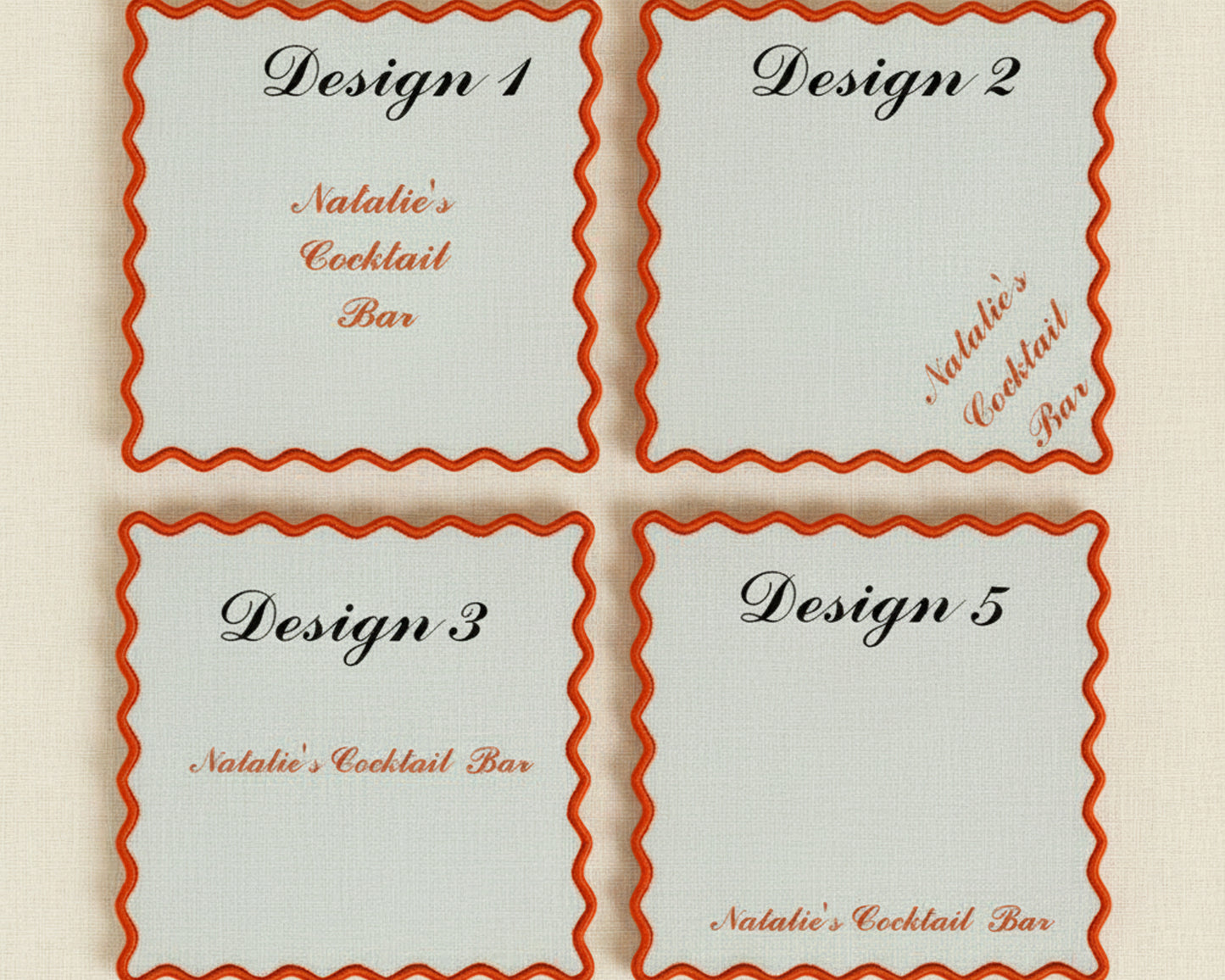 A variety of pink, blue, and cream linen napkins with scalloped edges featuring different custom bar names, cocktail icons, and French Bulldog embroidery.