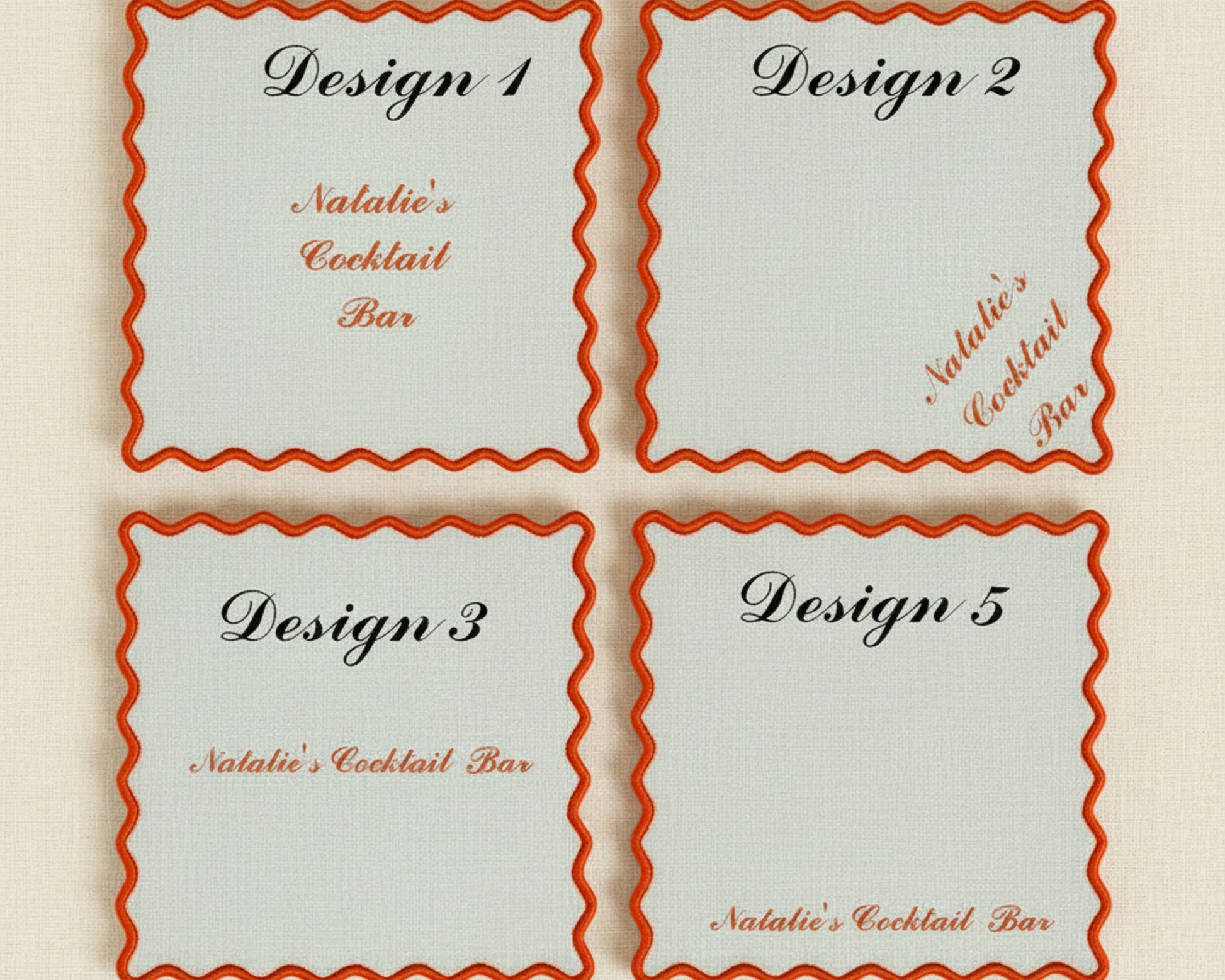 A variety of pink, blue, and cream linen napkins with scalloped edges featuring different custom bar names, cocktail icons, and French Bulldog embroidery.