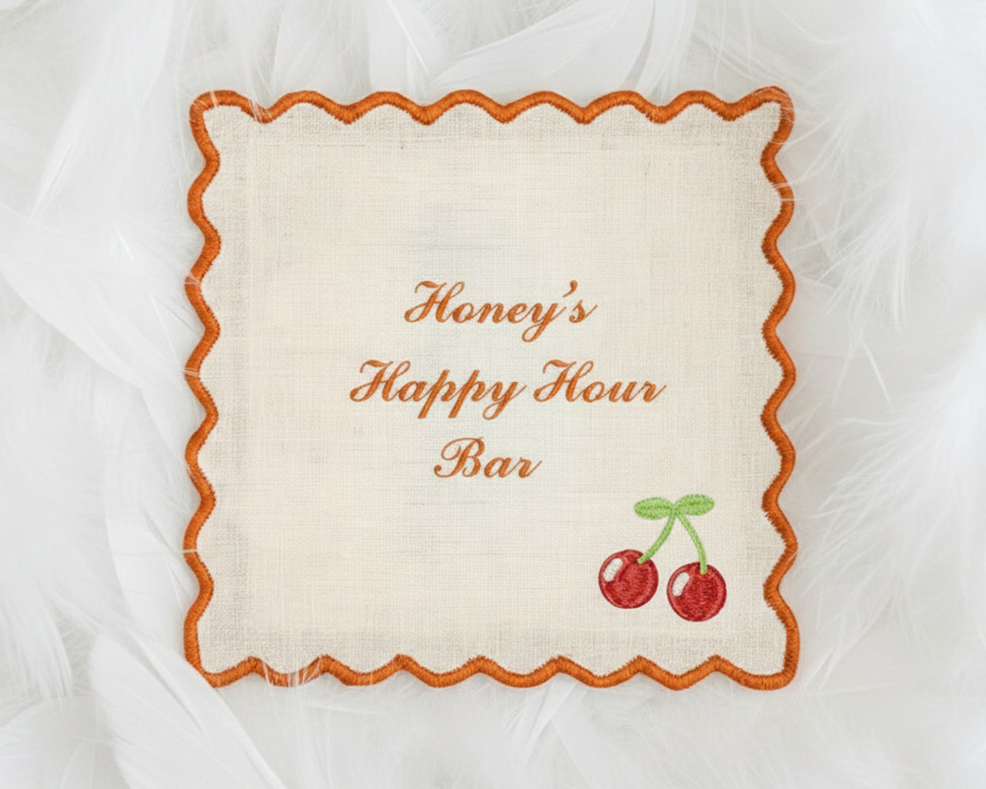 A collection of four light blue cotton cocktail napkins with white scalloped edges, each featuring personalized name embroidery and a pet icon.