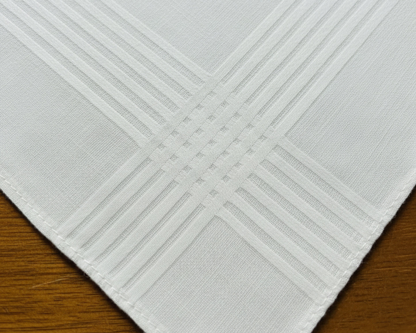 A white cotton keepsake handkerchief embroidered with a custom wedding message: "Molly & Brandon 8.20.22" in a sophisticated rose pink script.