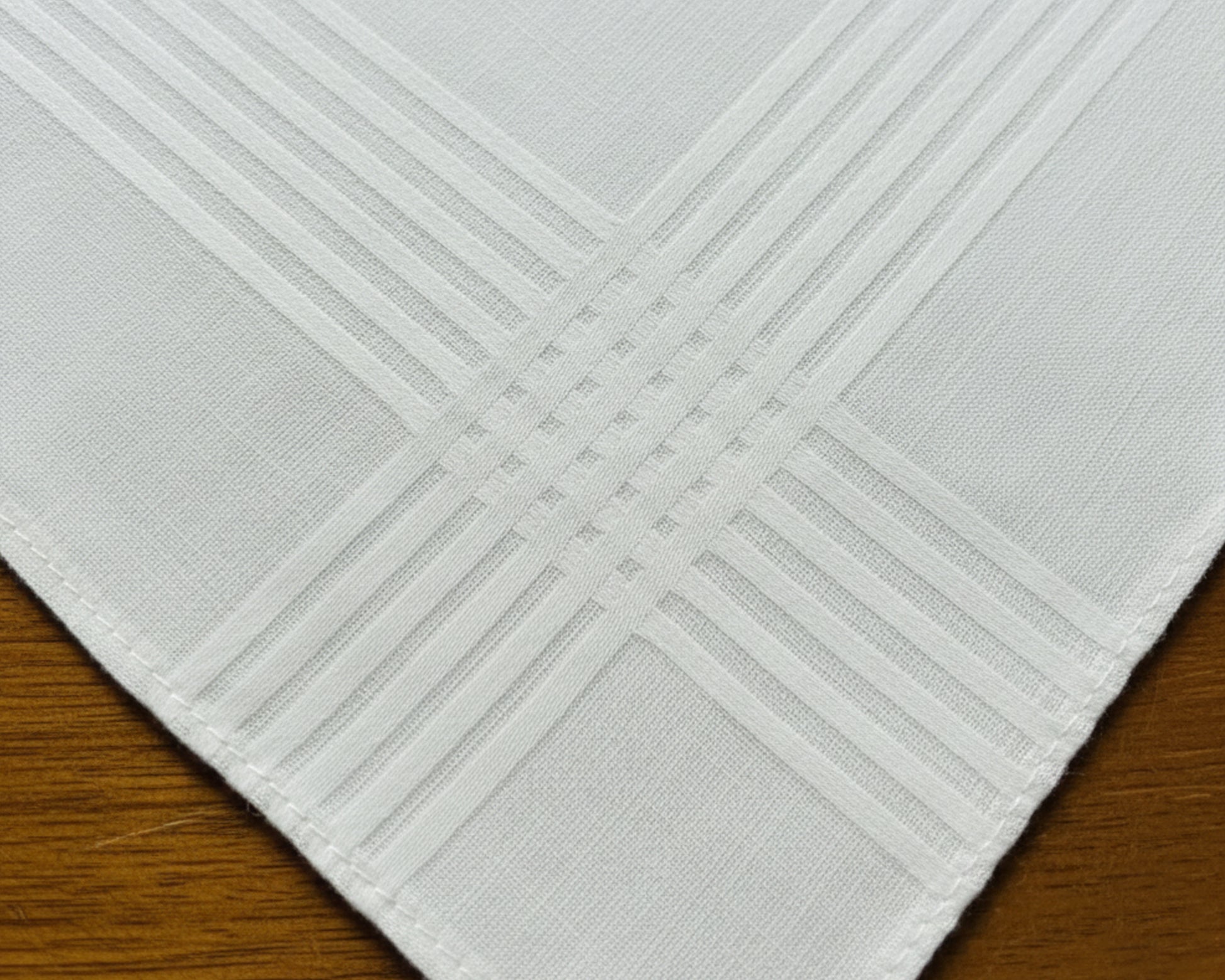 A white cotton keepsake handkerchief embroidered with a custom wedding message: "Molly & Brandon 8.20.22" in a sophisticated rose pink script.