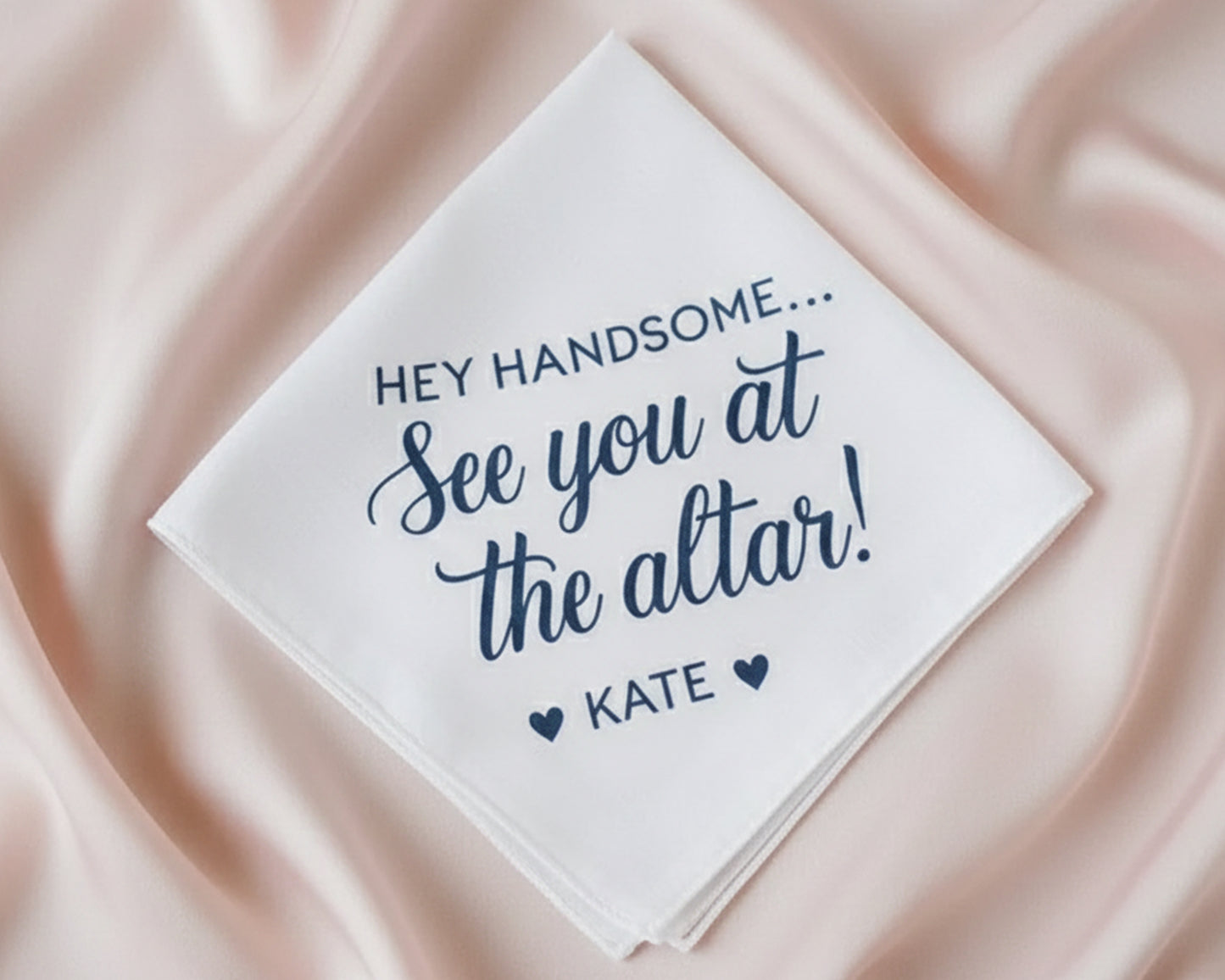 A white cotton wedding handkerchief with a navy blue vinyl print message: "HEY HANDSOME... See you at the altar! ❤ KATE ❤".