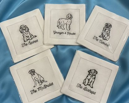 A crisp white cotton hemstitch napkin featuring a detailed black embroidered Doodle dog sitting next to a martini glass icon.