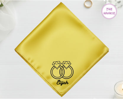 A radiant sunbeam yellow satin handkerchief featuring "Elijah" and black embroidery of two gemstone rings entwined together.