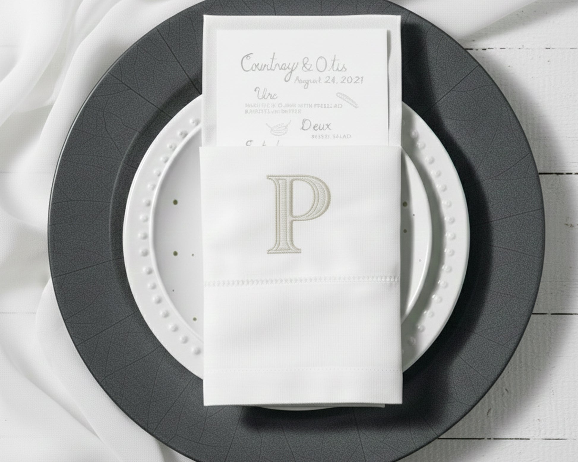 Embroidered cotton napkin with classic P monogram used as elegant table napkin holder