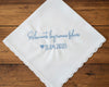 A customized 100% cotton handkerchief featuring the Spanish sentiment for happy tears and a wedding date, placed on a rustic dark wood surface.