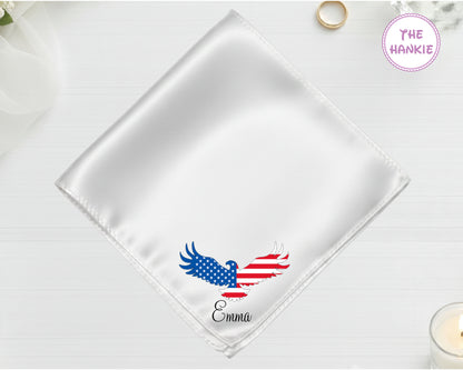 A shimmering pearl white high-lustre satin pocket square customized with "Emma" and a vibrant American flag eagle embroidery.