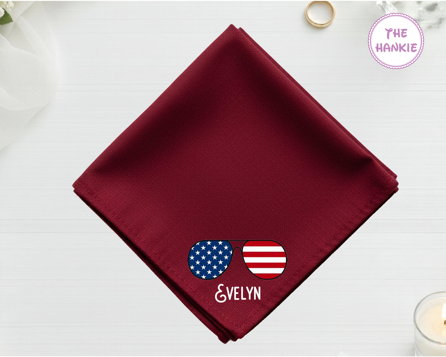 A spring maroon cotton handkerchief customized with the name "evelyn" and a vibrant, waving American flag embroidery.