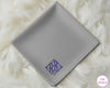 A modern grey cotton handkerchief featuring a personalized dark blue diamond-style crest monogram with the initials "BB".