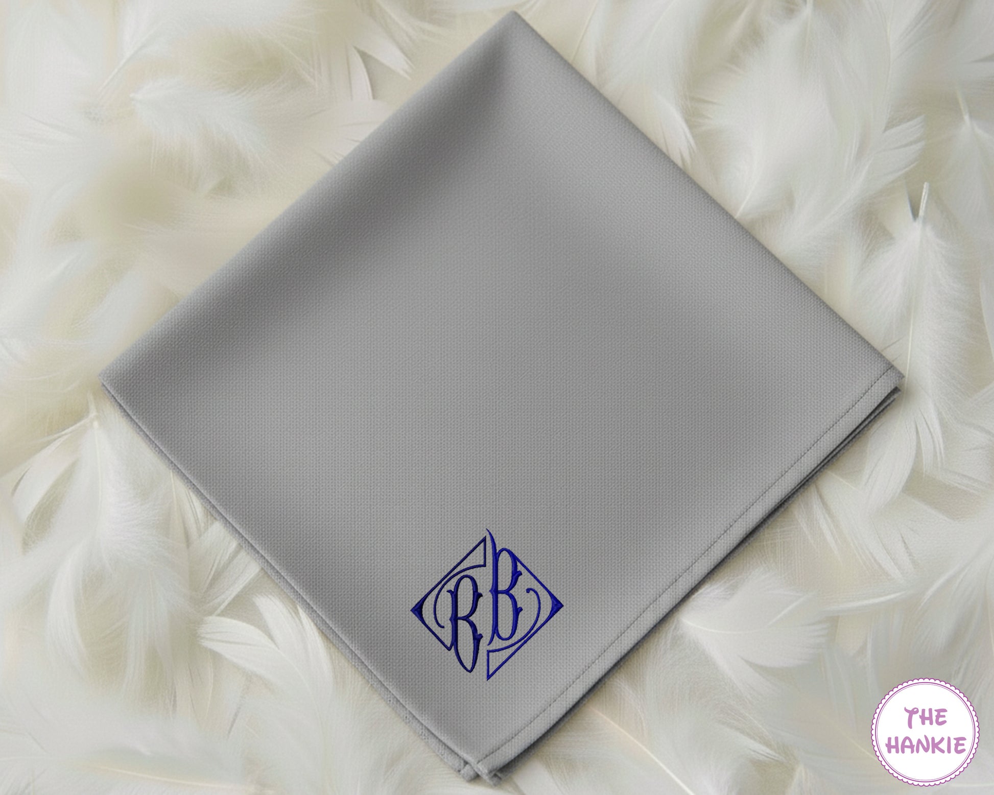 A modern grey cotton handkerchief featuring a personalized dark blue diamond-style crest monogram with the initials "BB".