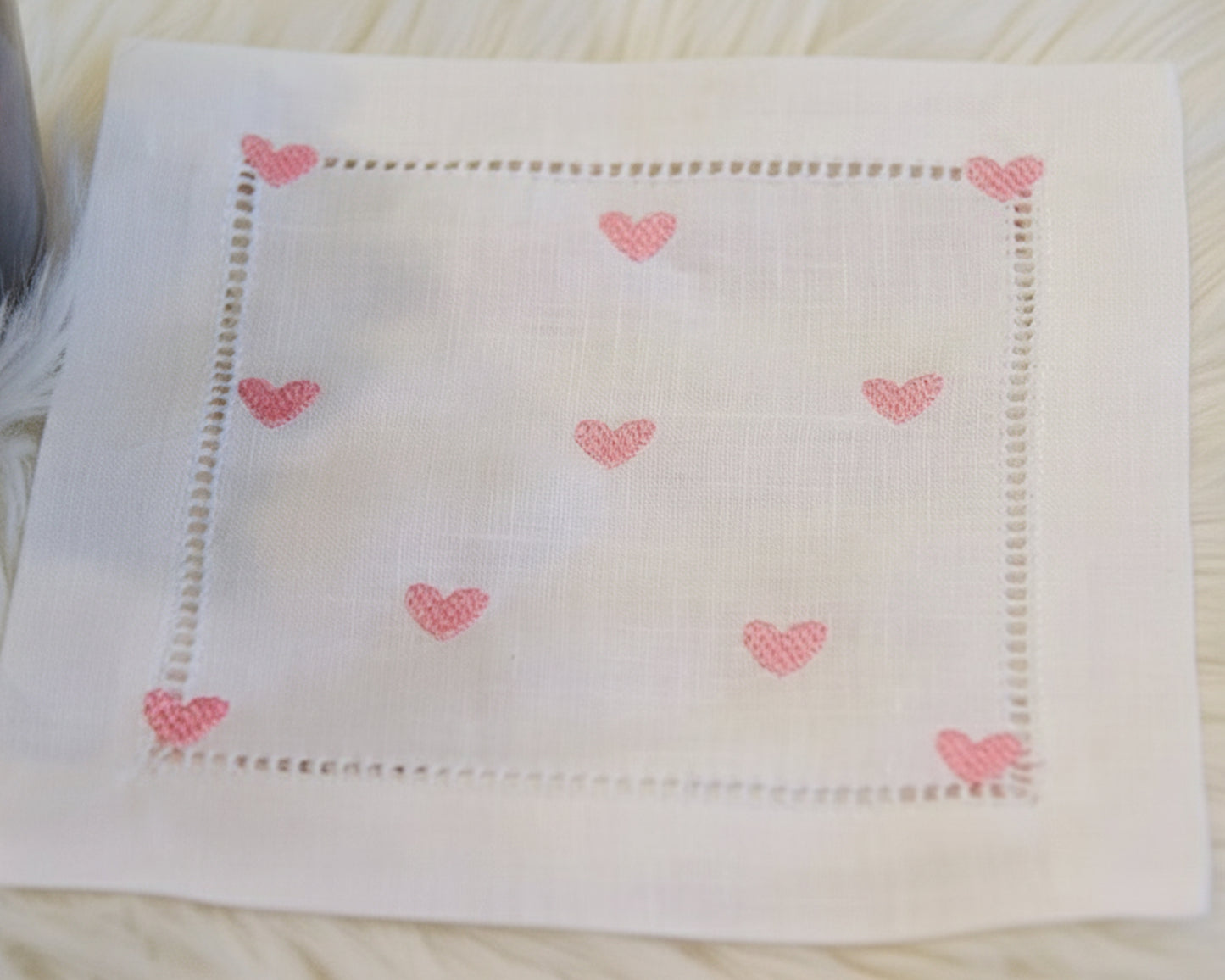 Close‑up of white cotton handkerchief featuring delicate pink heart embroidery


