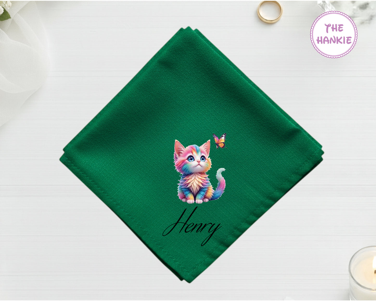 A lush forest green luxury satin handkerchief featuring the name "Henry" and a whimsical, pastel-colored rainbow kitten looking up at a butterfly.