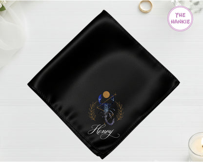 A midnight onyx black luxury satin pocket square customized with the name "Henry" below a high-definition blue and gold vinyl Scorpio zodiac icon.