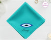 A radiant turquoise cotton handkerchief customized with "Henry" below a minimalist blue, black, and white circular Nazar evil eye design.