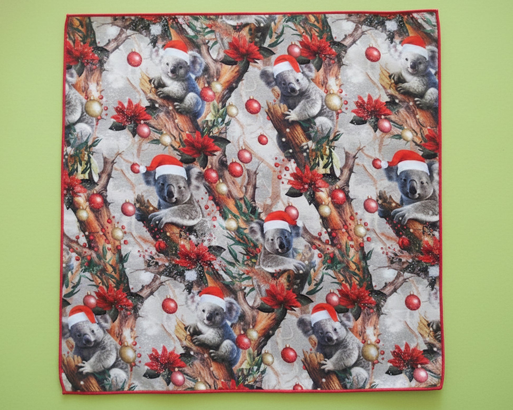 Single children’s premium satin handkerchief displaying a repeat pattern of Christmas koalas and ornaments.