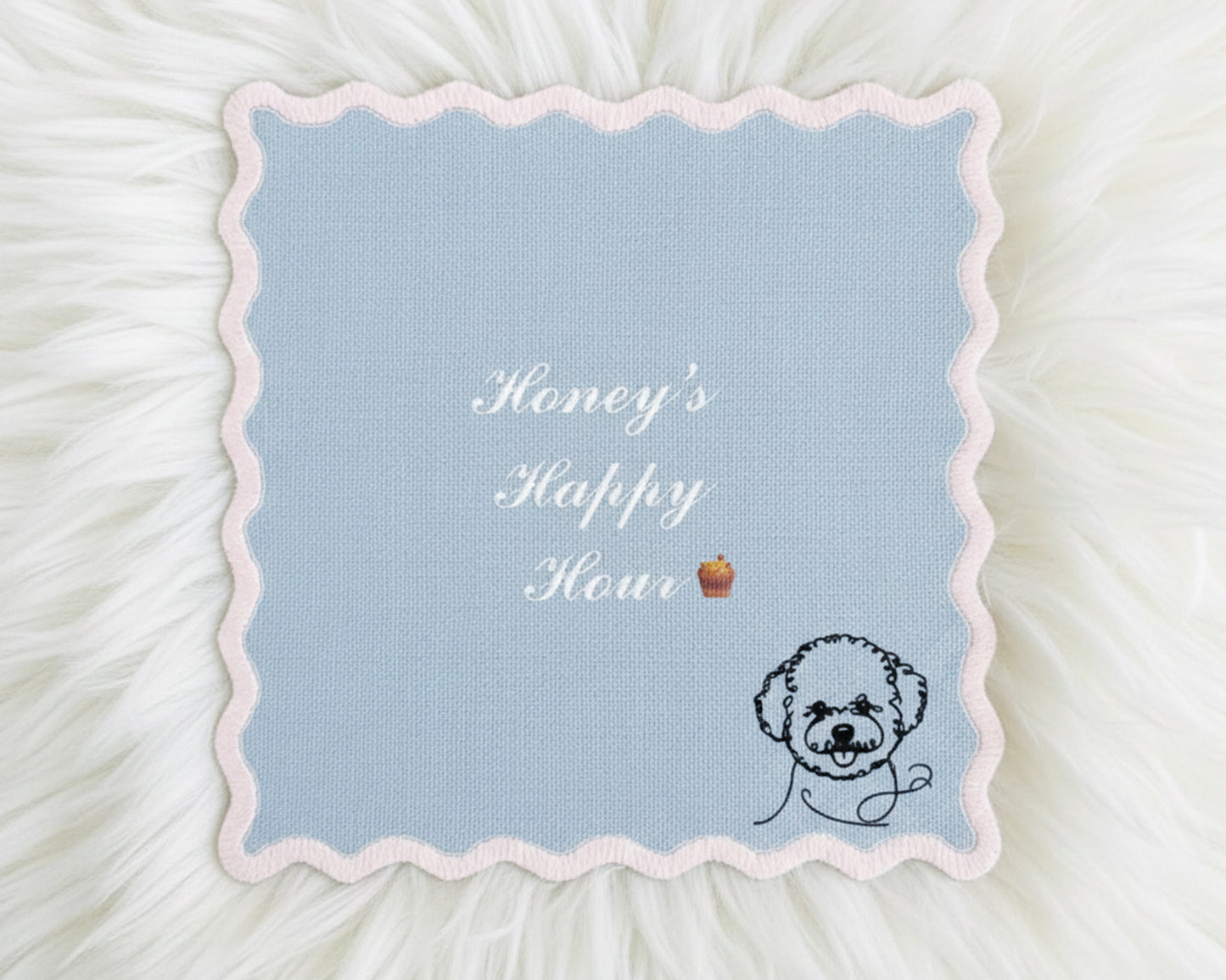 A light blue scalloped-edge cotton bar napkin featuring white embroidered text "Honey's Happy Hour" and a minimalist black-line poodle icon.