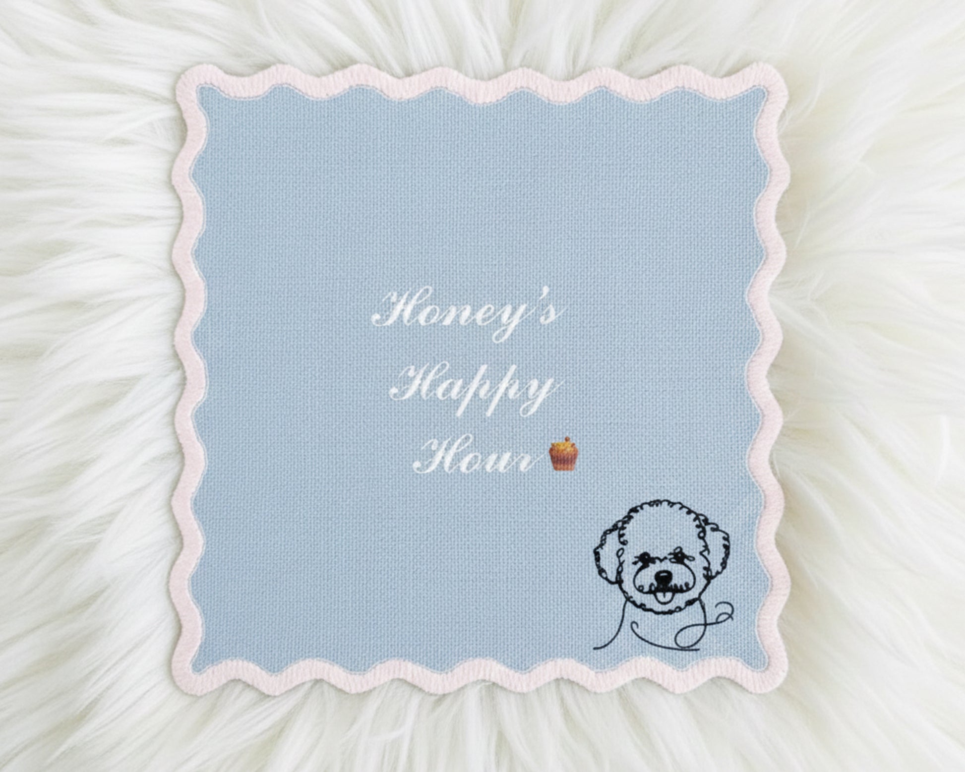 A light blue scalloped-edge cotton bar napkin featuring white embroidered text "Honey's Happy Hour" and a minimalist black-line poodle icon.