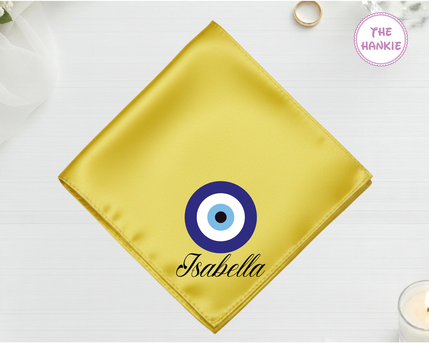 A radiant gold luxury satin handkerchief personalized with the name "Isabella" below a classic blue-and-white circular Nazar evil eye design.