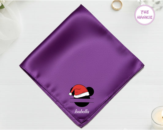 A royal purple luxury satin handkerchief personalized with the name "Isabella" below a Mickey Mouse silhouette wearing a red and white Santa hat.