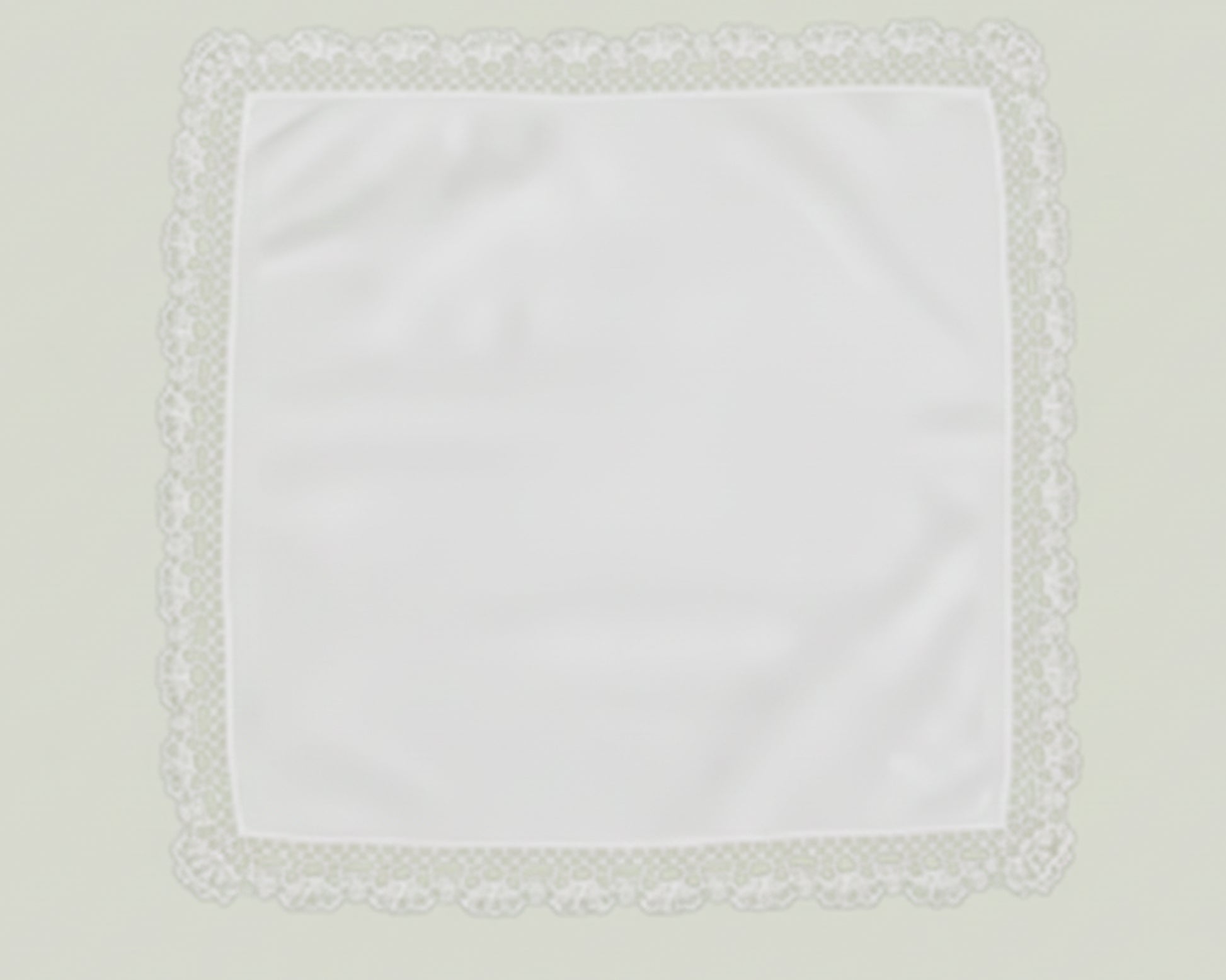 Close up detail of a white cotton handkerchief featuring a delicate geometric lace trim border.