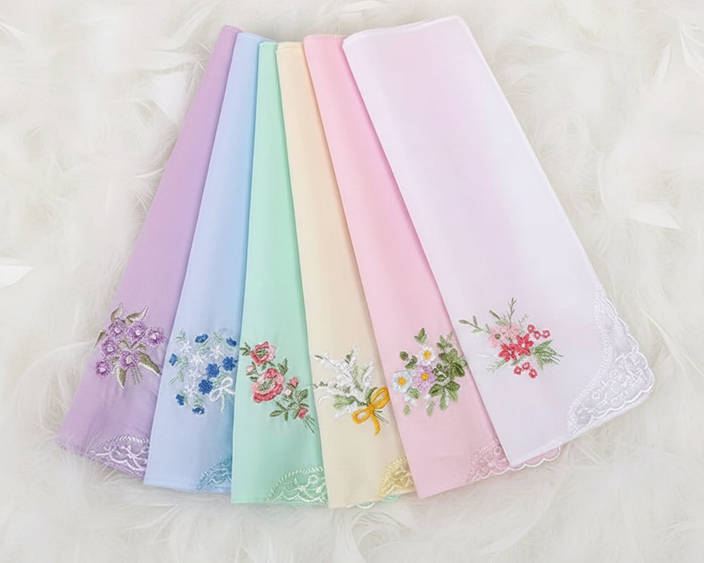 Close-up of pastel pink and lilac handkerchiefs showing intricate lace borders and flower details.