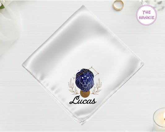 A shimmering pearl white luxury satin handkerchief personalized with the name "Lucas" below a high-definition blue and gold vinyl Leo zodiac icon.
